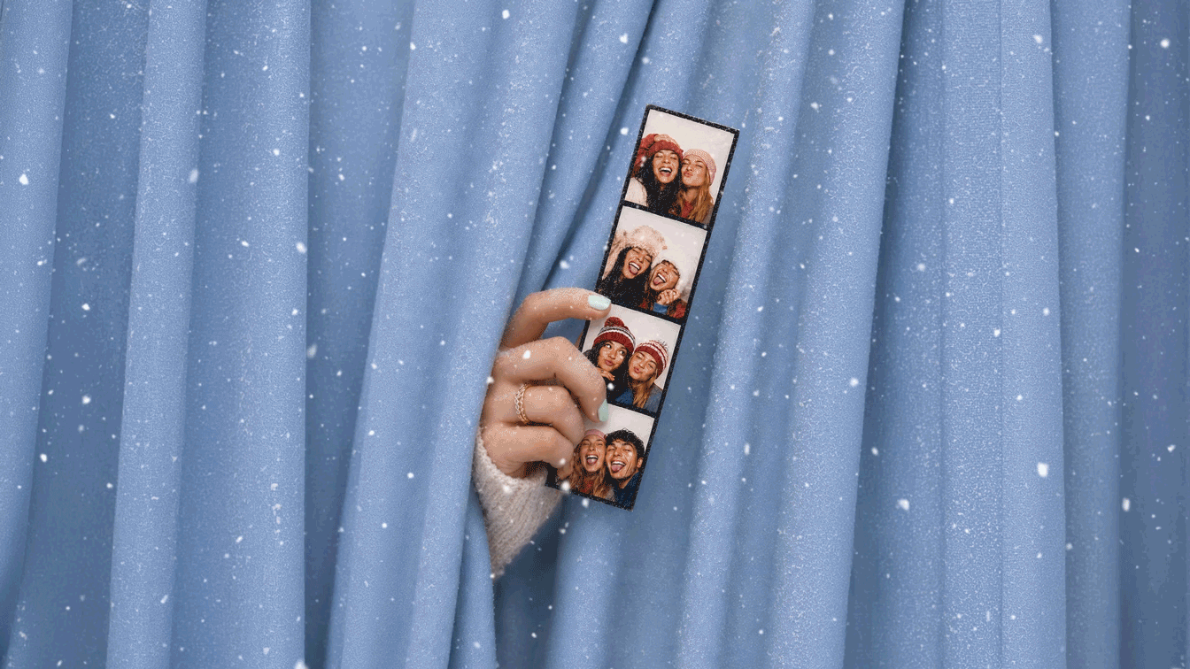 Friends smiling and posing inside the neon-lit WinterFest photobooth