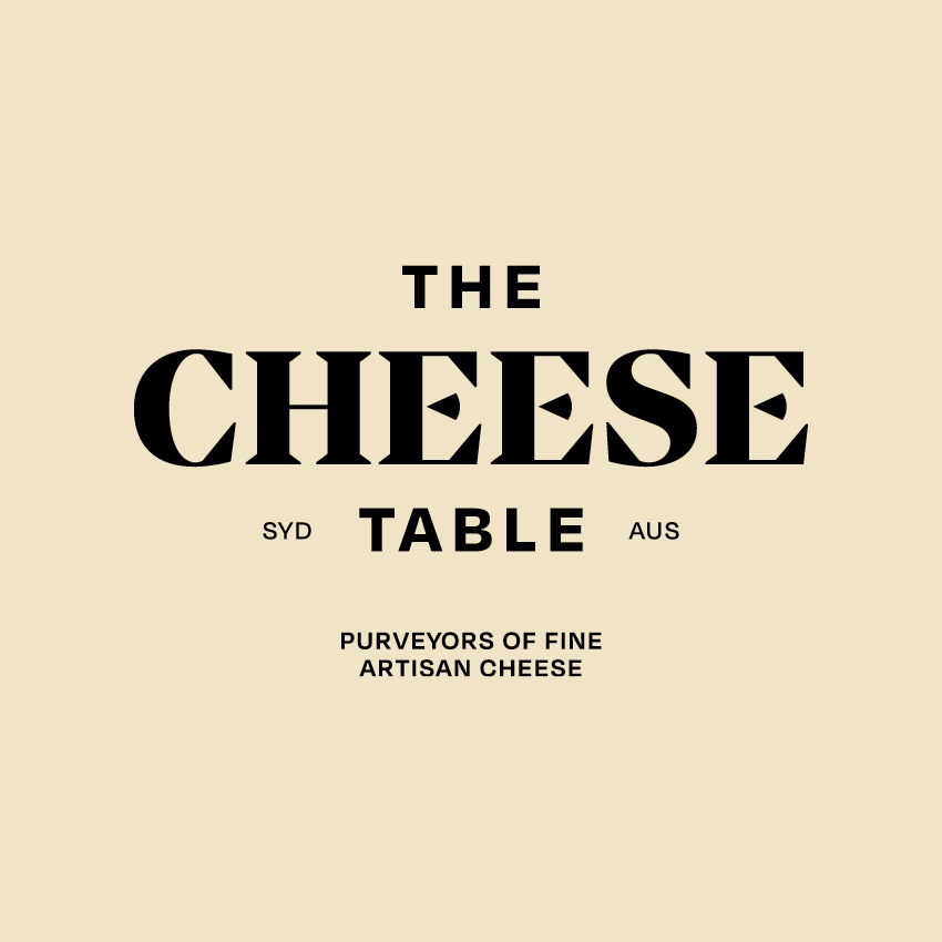 A beautifully arranged cheese board with a variety of cheeses, fruits, and crackers on a wooden table at Hay St Market at Paddy's.